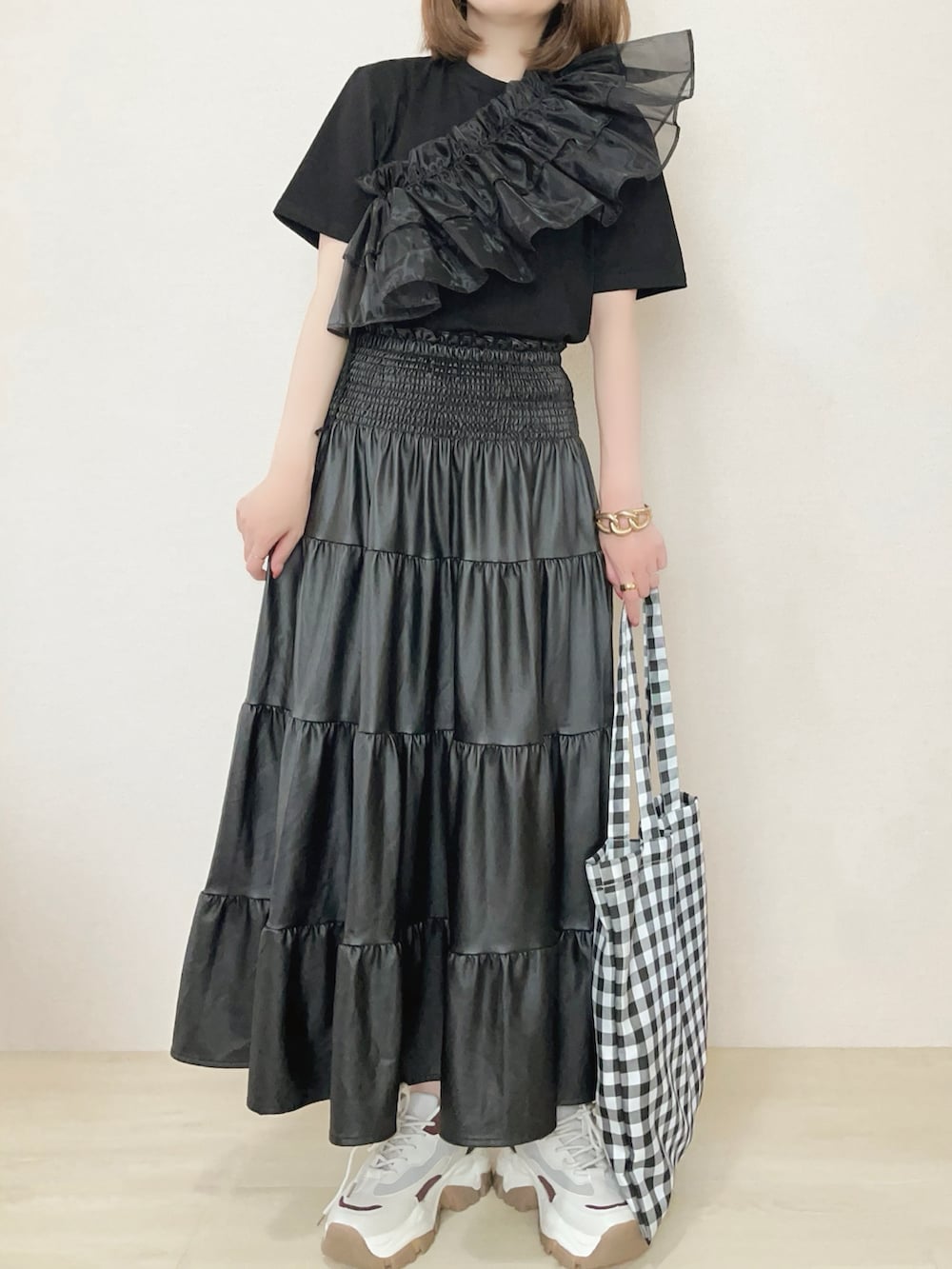 ブラック系のアンサンブル、ブラック系のスカートを着用したレディースの春コーディネートの2枚目の写真