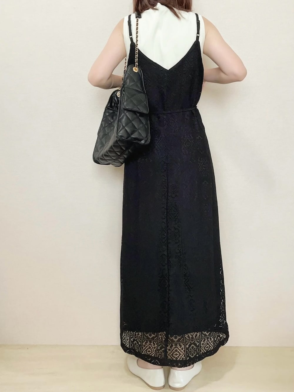 ブラック系のワンピース、ブラック系のショルダーバッグを着用したレディースの春コーディネートの3枚目の写真