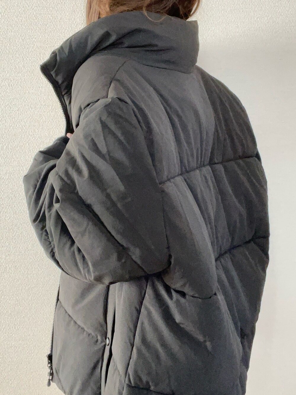 ブラック系のダウンジャケット/コート、ホワイト系のTシャツ/カットソー、ブラック系のブーツを着用したレディースの秋コーディネートの5枚目の写真