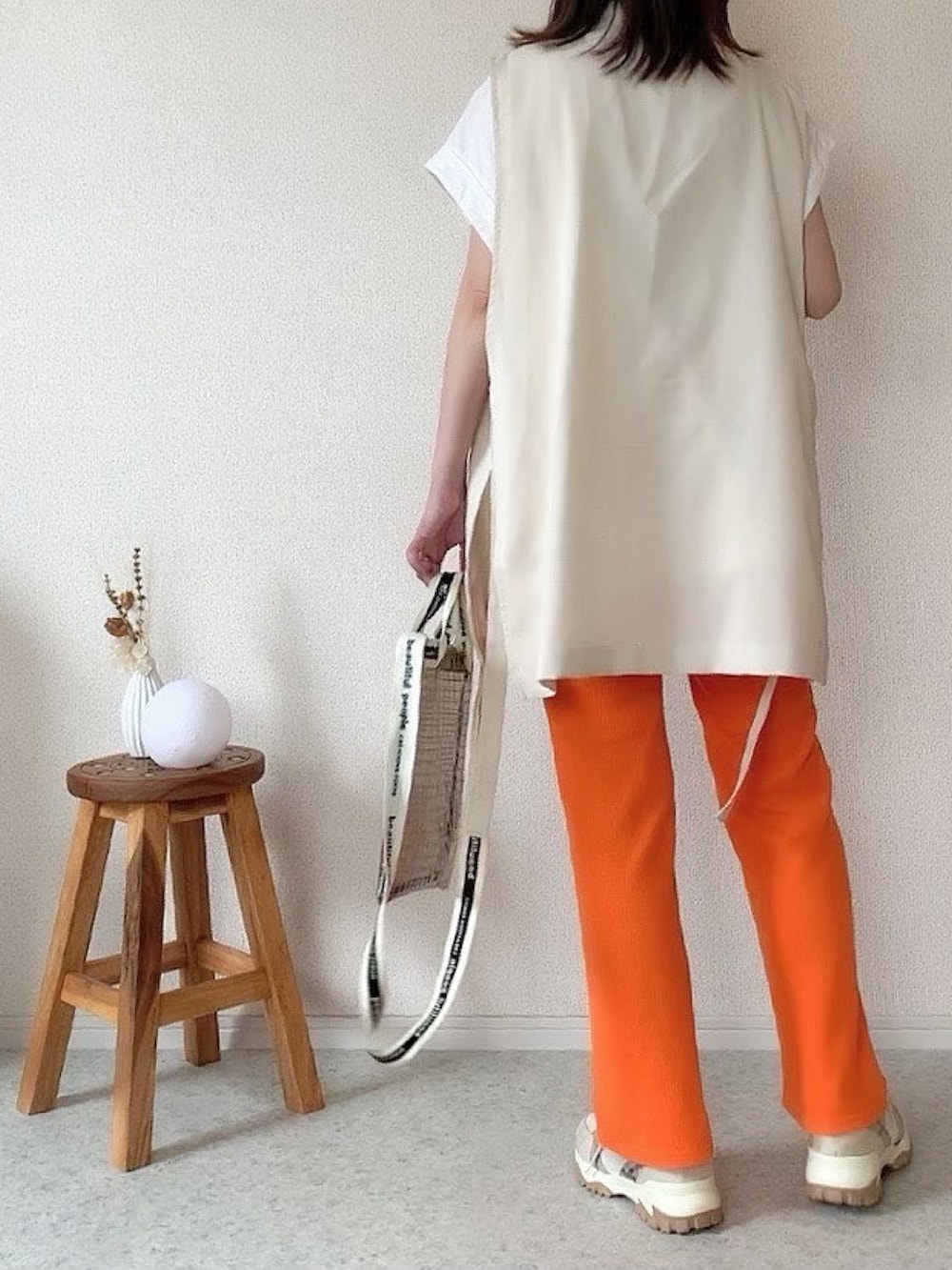 ブラック系のショルダーバッグ、その他のスニーカー、オレンジ系のパンツを着用したレディースの夏コーディネートの3枚目の写真