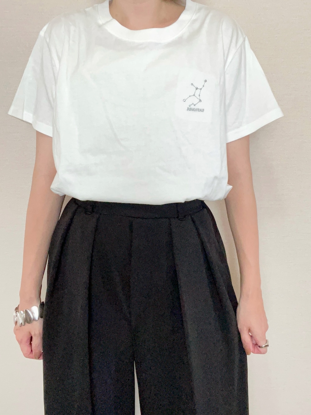 ブラック系のスラックス、ブラック系のバックパック/リュック、ホワイト系のTシャツ/カットソーを着用したレディースの夏コーディネートの5枚目の写真