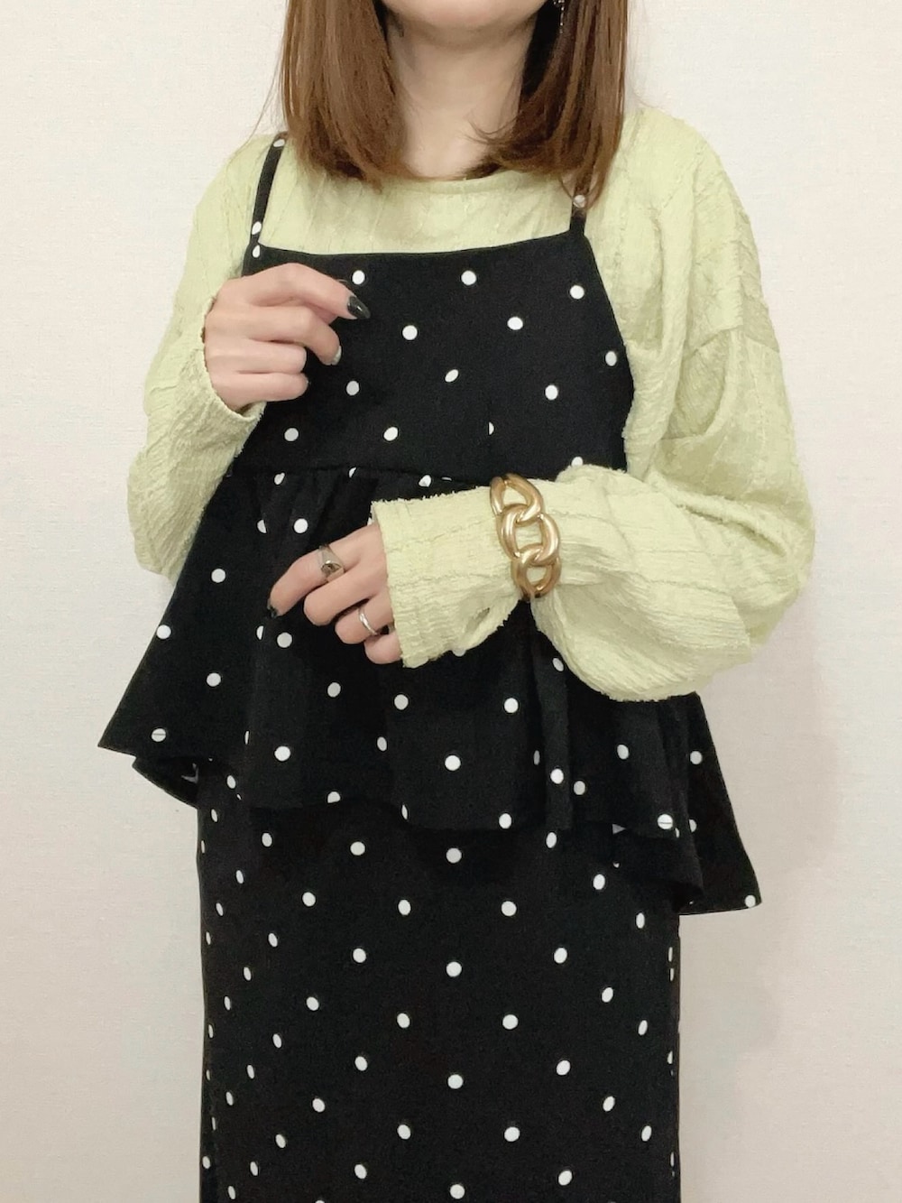 グリーン系のTシャツ/カットソー、ブラック系のワンピースを着用したレディースの春コーディネートの3枚目の写真