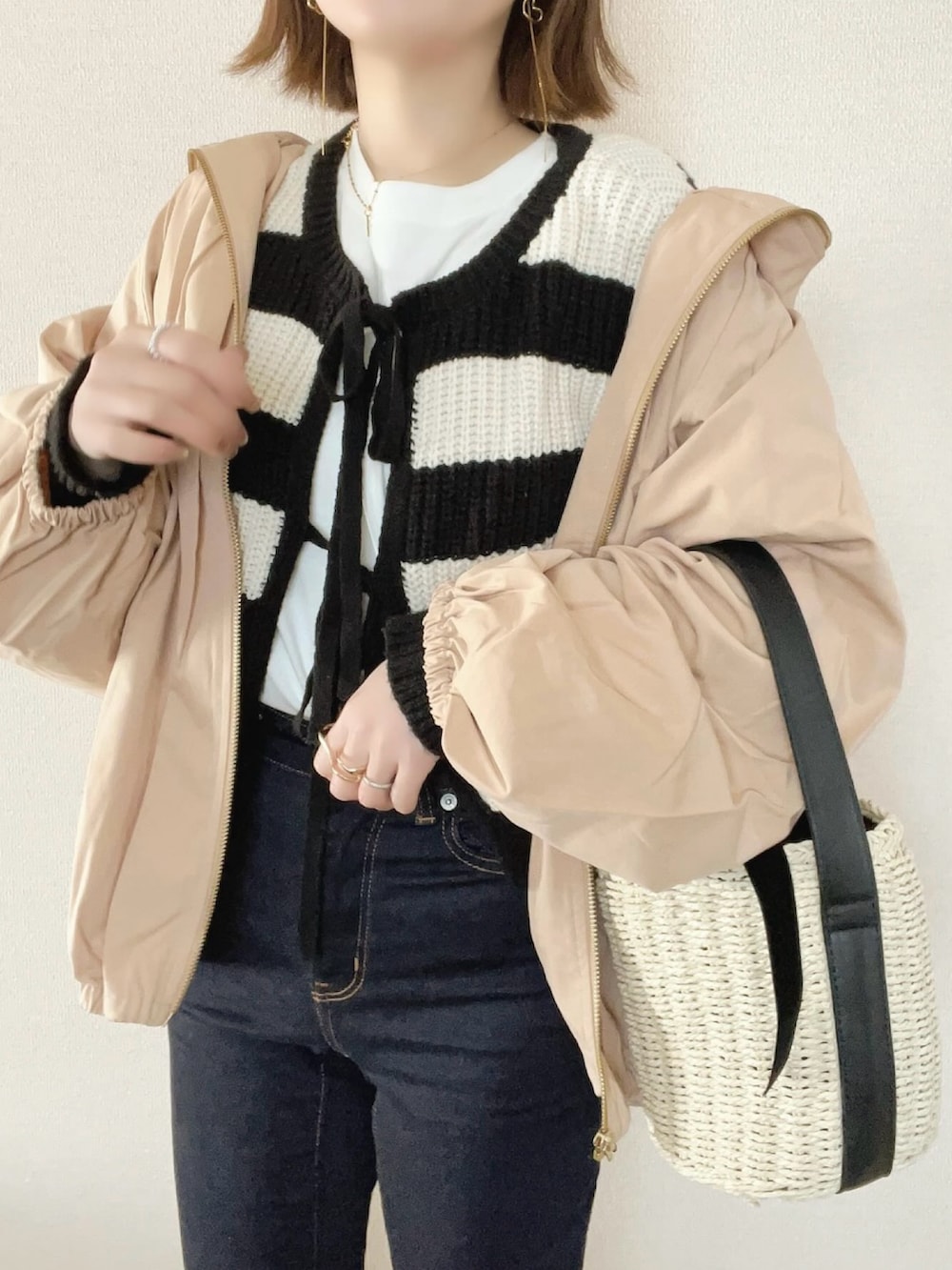 ベージュ系のブルゾン、ブラック系のカーディガン/ボレロを着用したレディースの春コーディネートの4枚目の写真