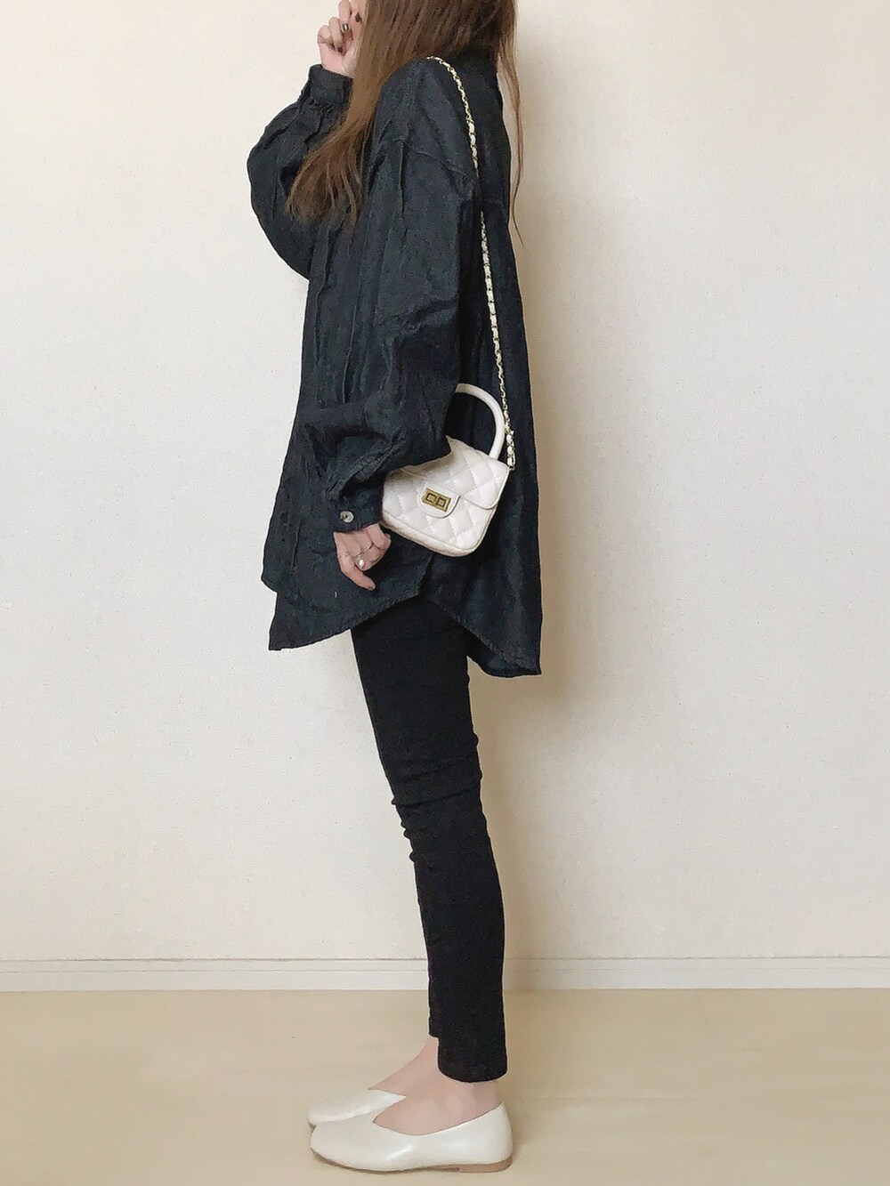 ブラック系のシャツ/ブラウス、ブラック系のデニムパンツ、ゴールド系のピアス（両耳用）を着用したレディースの秋コーディネートの2枚目の写真