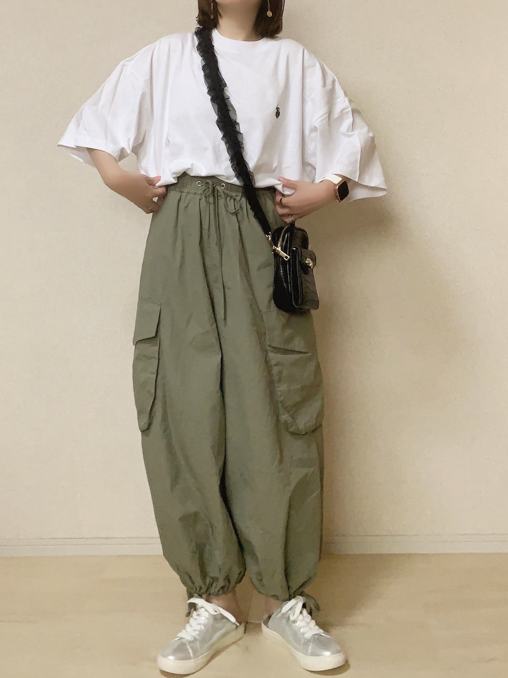 ホワイト系のTシャツ/カットソー、グリーン系のカーゴパンツ、シルバー系のスニーカーを着用したレディースの春コーディネートの2枚目の写真
