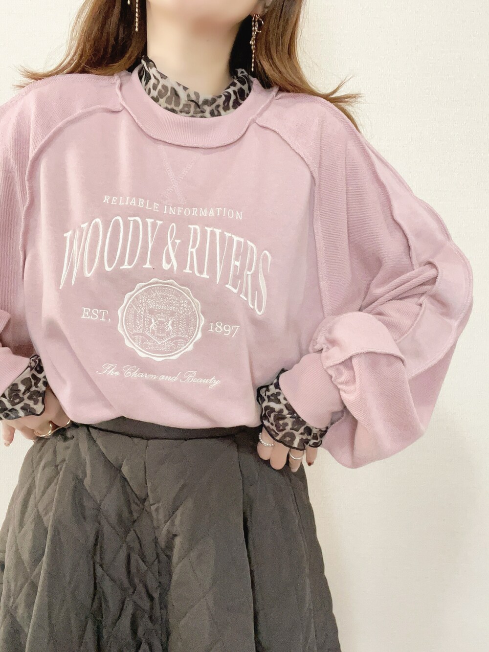 ピンク系のスウェット、ブラウン系のスカート、ブラック系のブーツを着用したレディースの冬コーディネートの4枚目の写真