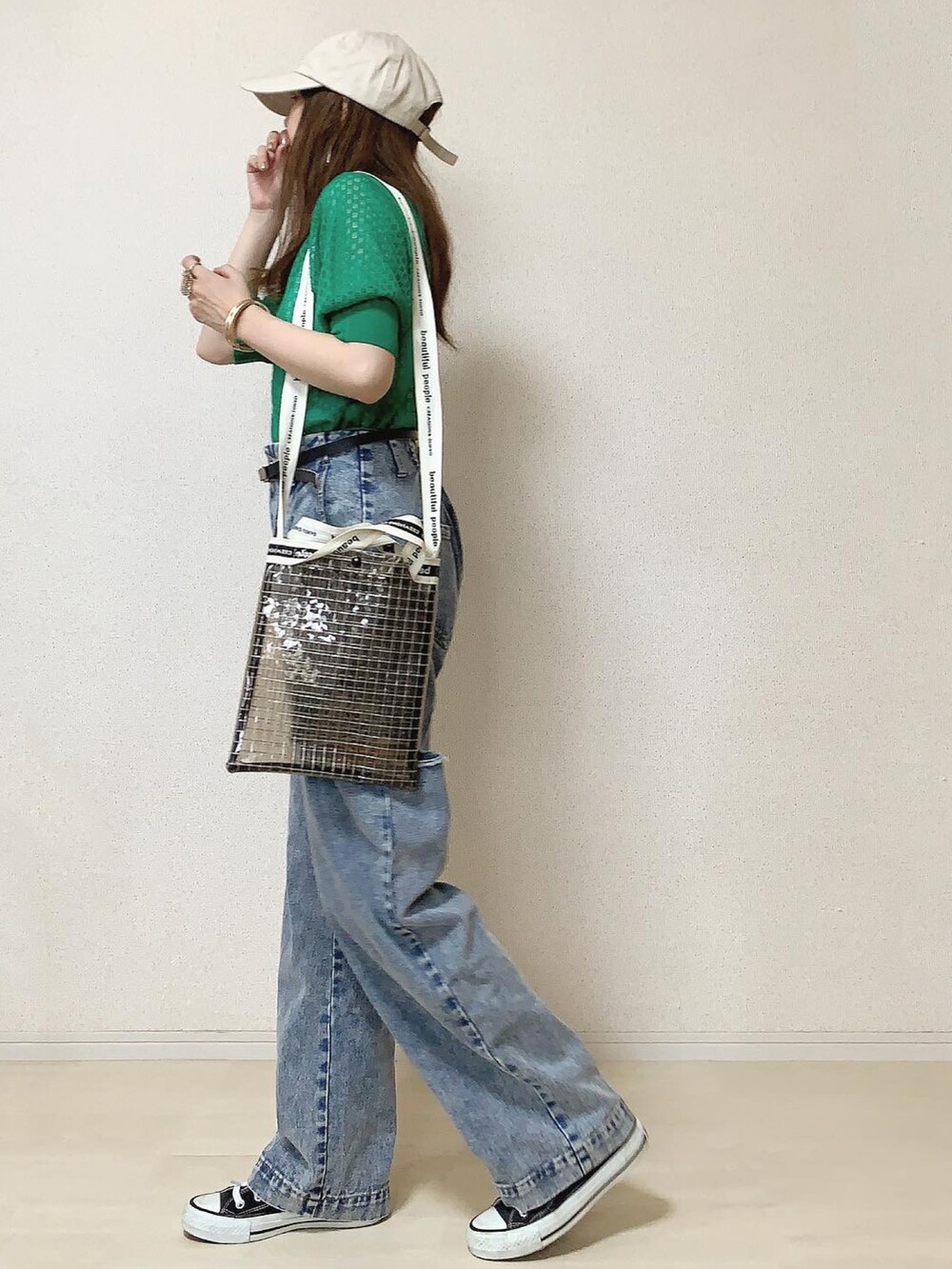 ブラック系のスニーカー、ブラック系のショルダーバッグ、グリーン系のニット/セーターを着用したレディースの夏コーディネートの2枚目の写真