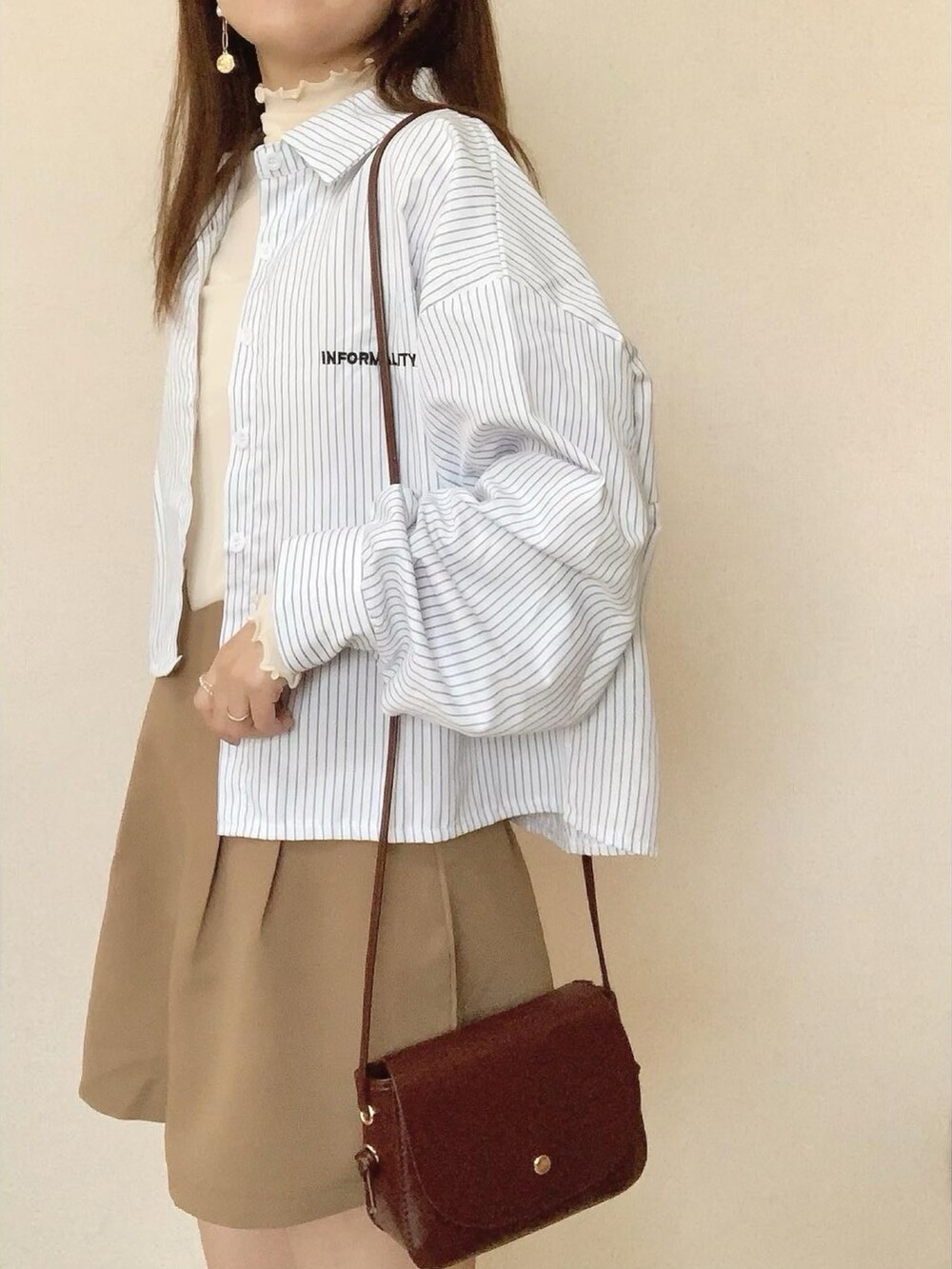 ベージュ系のその他パンツ、ブラウン系のショルダーバッグ、ホワイト系のTシャツ/カットソーを着用したレディースの春コーディネートの2枚目の写真