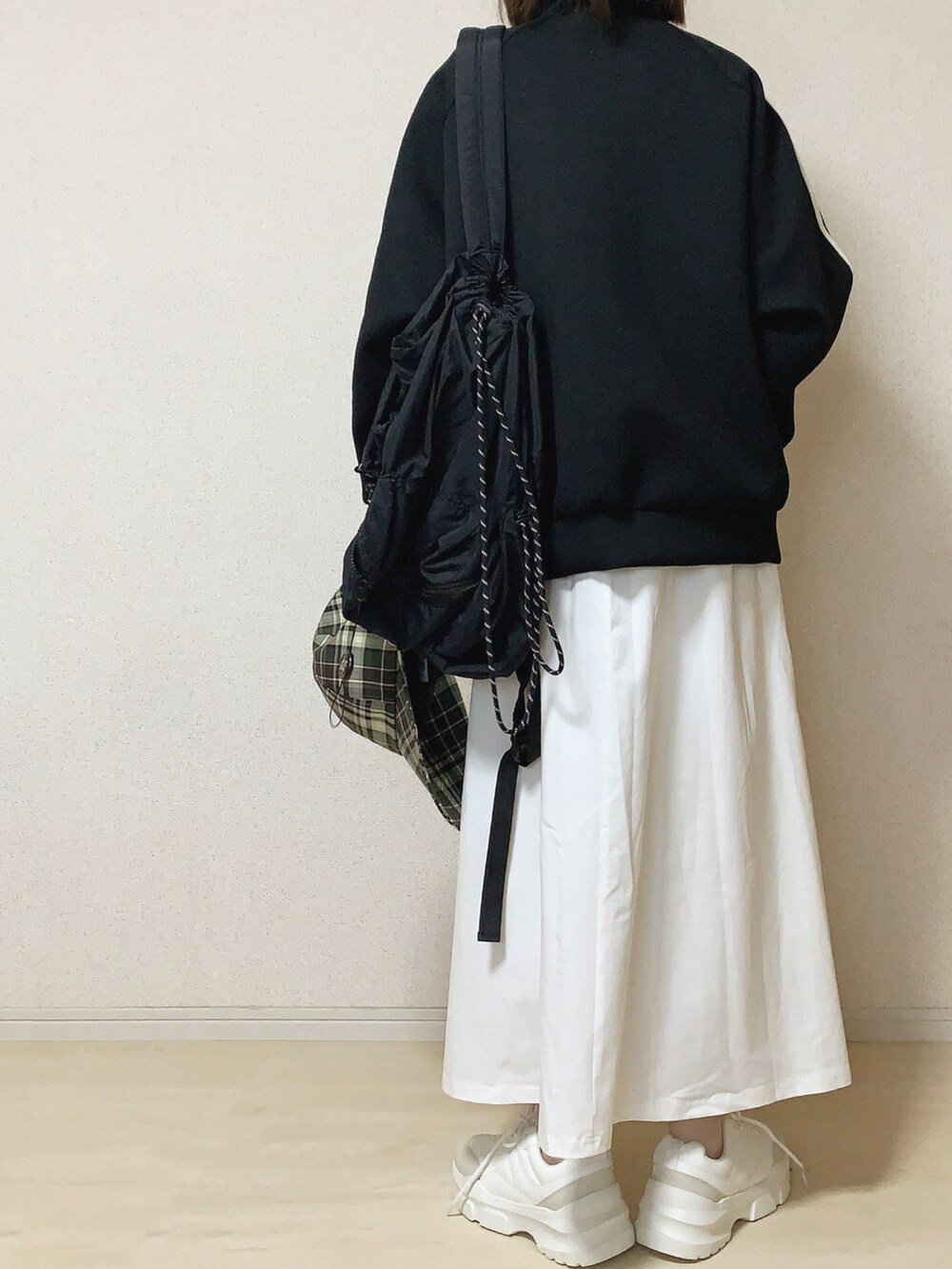 ホワイト系のワンピース、ブラック系のバックパック/リュックを着用したレディースの春コーディネートの3枚目の写真