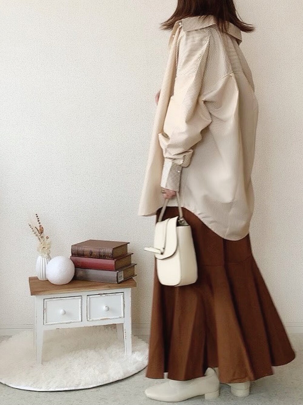 ホワイト系のブーツ、ゴールド系のネックレスを着用したレディースの秋コーディネートの2枚目の写真