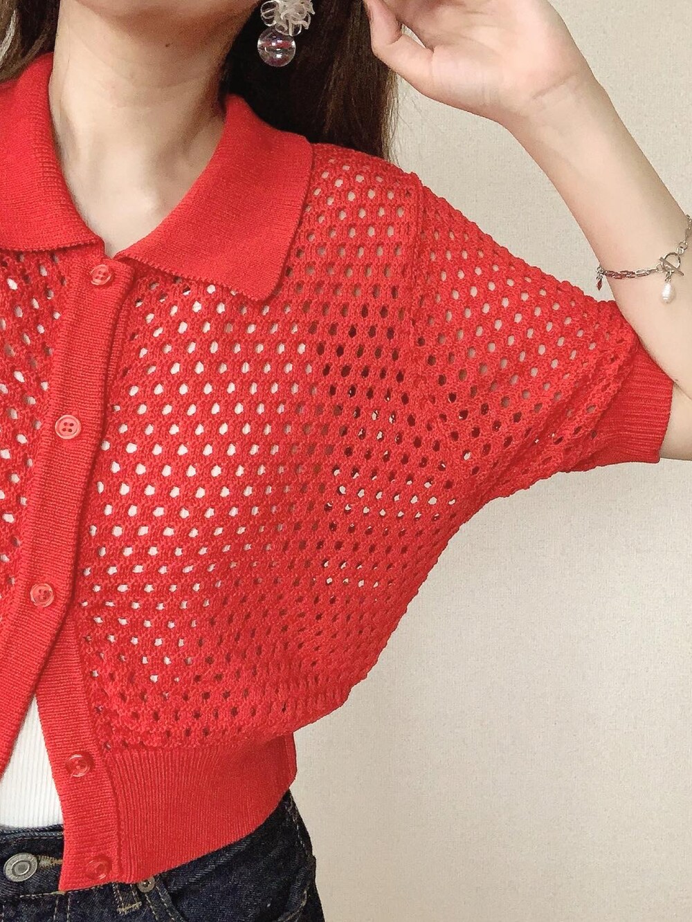 レッド系のカーディガン/ボレロ、ブルー系のデニムパンツ、ブラック系のバレエシューズを着用したレディースの春コーディネートの2枚目の写真