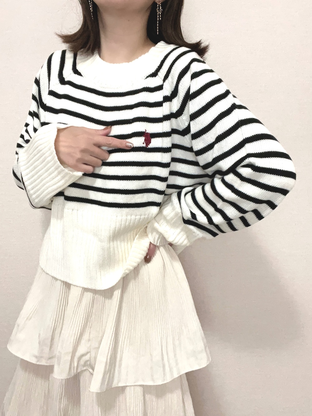 ホワイト系のニット/セーター、ベージュ系のスカート、ブラック系のブーツを着用したレディースの冬コーディネートの4枚目の写真