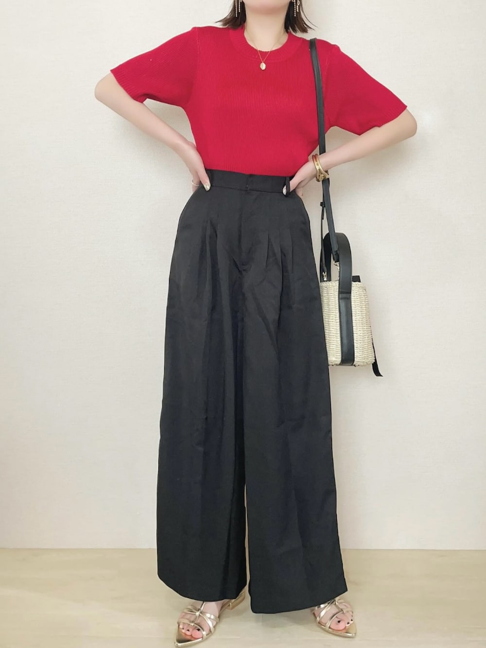 ブラック系のスラックス、レッド系のニット/セーターを着用したレディースの春コーディネートの2枚目の写真