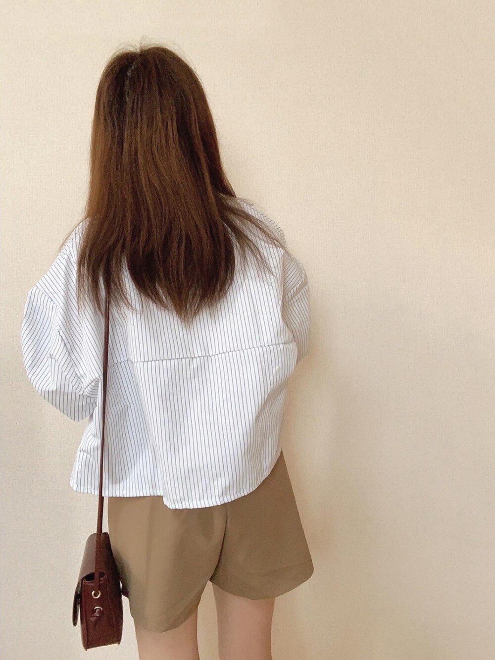 ベージュ系のその他パンツ、ブラウン系のショルダーバッグ、ホワイト系のTシャツ/カットソーを着用したレディースの春コーディネートの4枚目の写真