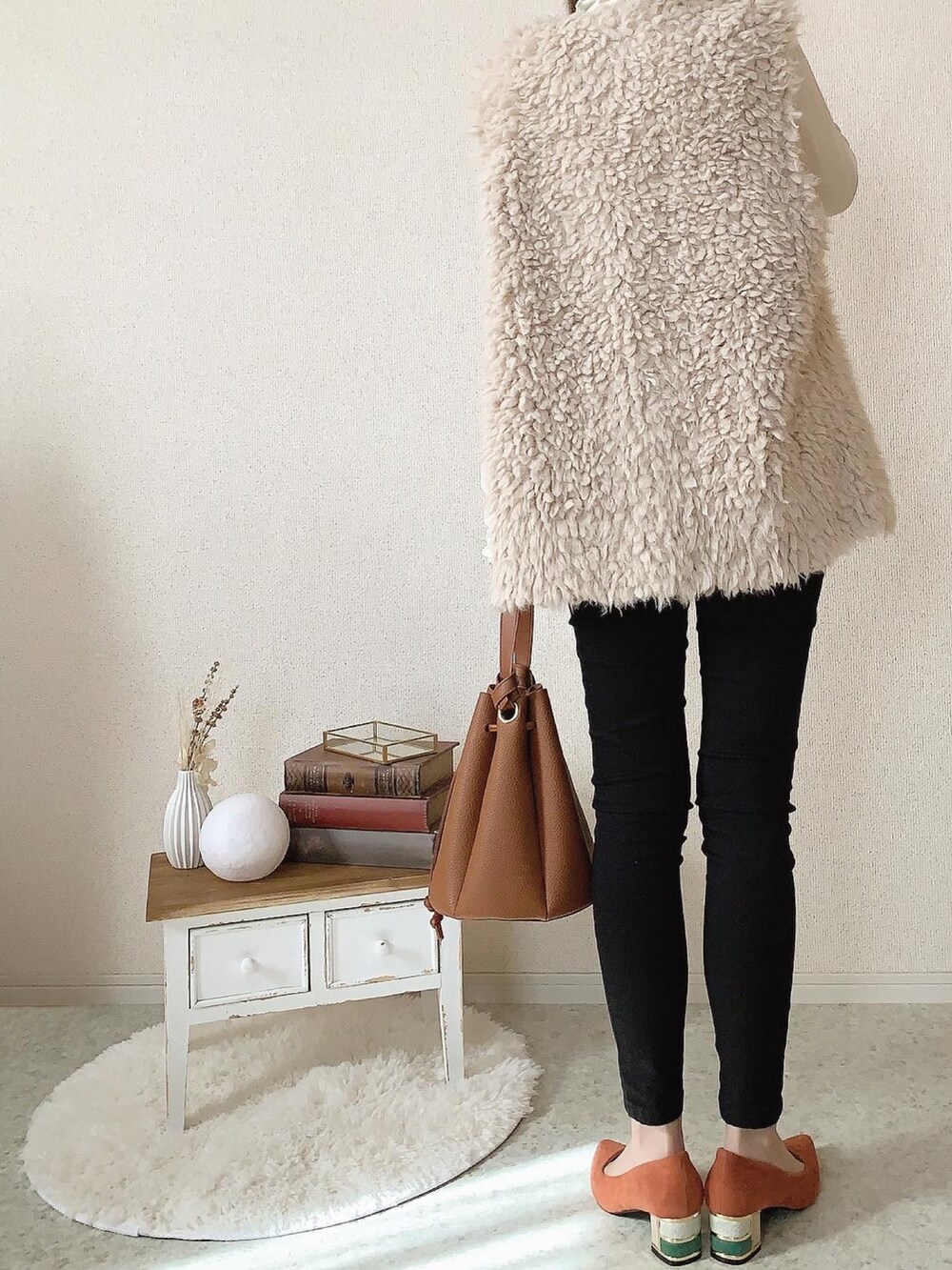 ブラック系のデニムパンツ、オレンジ系のパンプスを着用したレディースの秋コーディネートの3枚目の写真