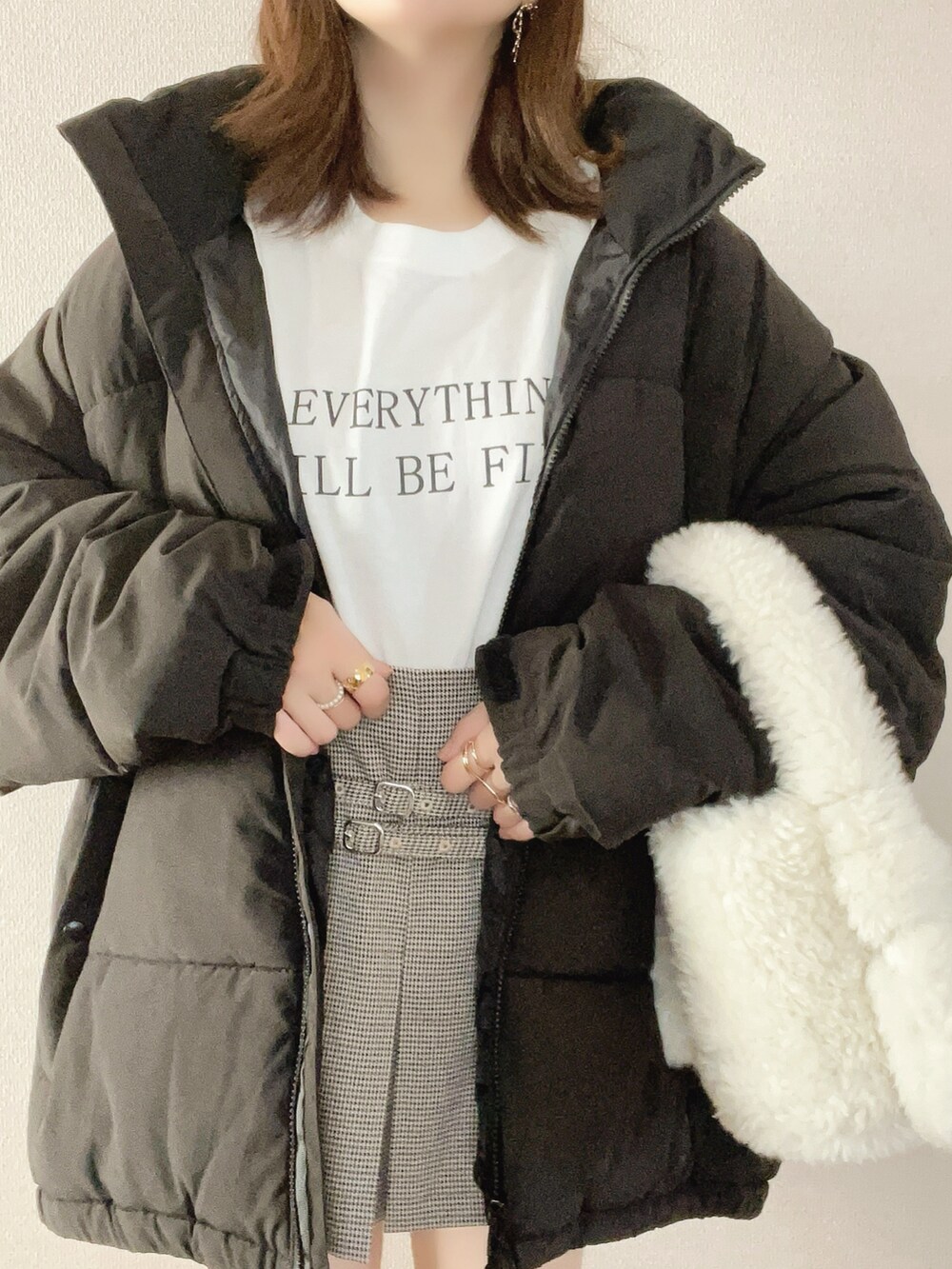 ブラック系のダウンジャケット/コート、ホワイト系のTシャツ/カットソー、ブラック系のブーツを着用したレディースの秋コーディネートの4枚目の写真