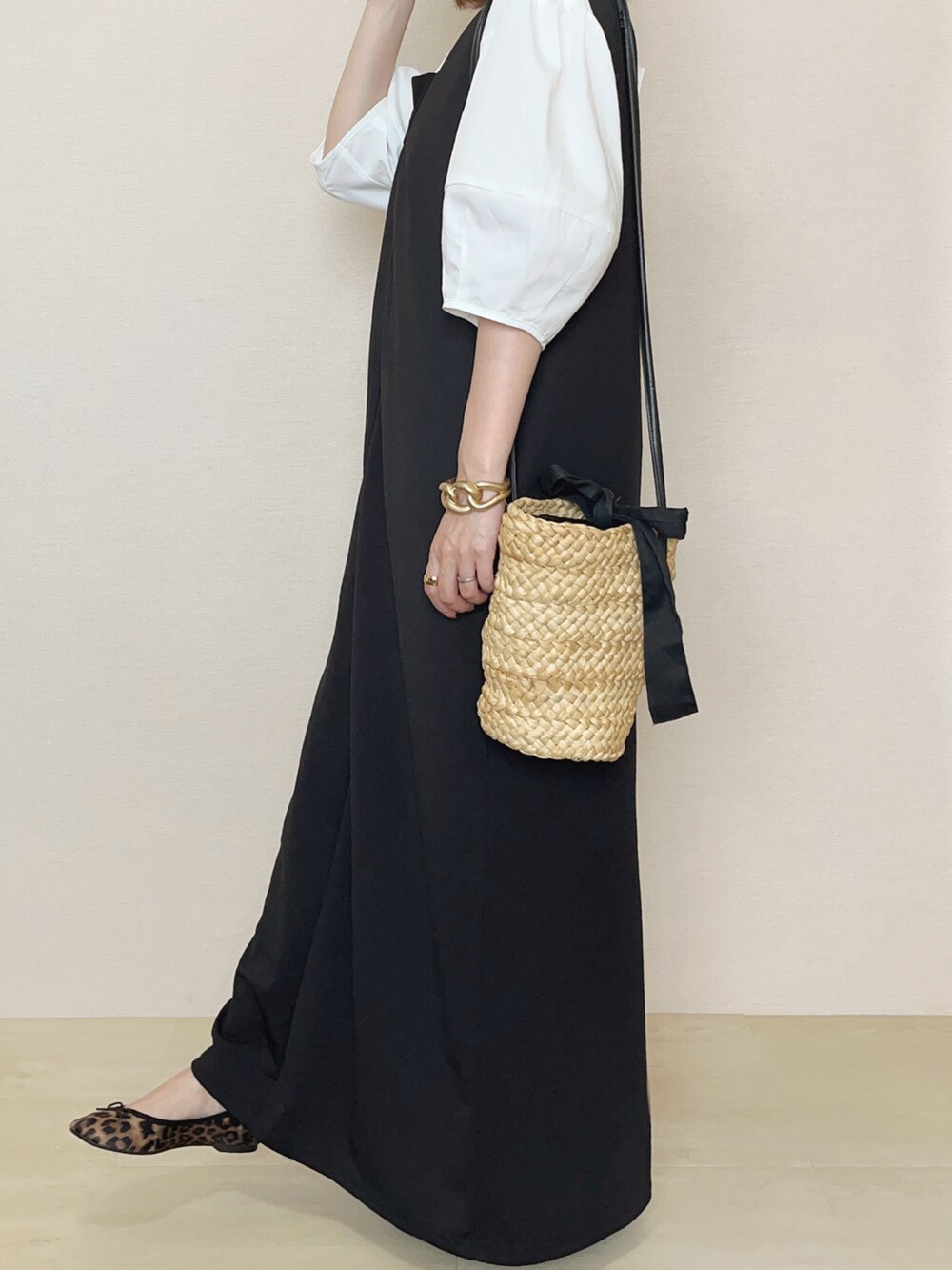 ブラック系のジャンパースカート、ホワイト系のシャツ/ブラウスを着用したレディースの夏コーディネートの3枚目の写真