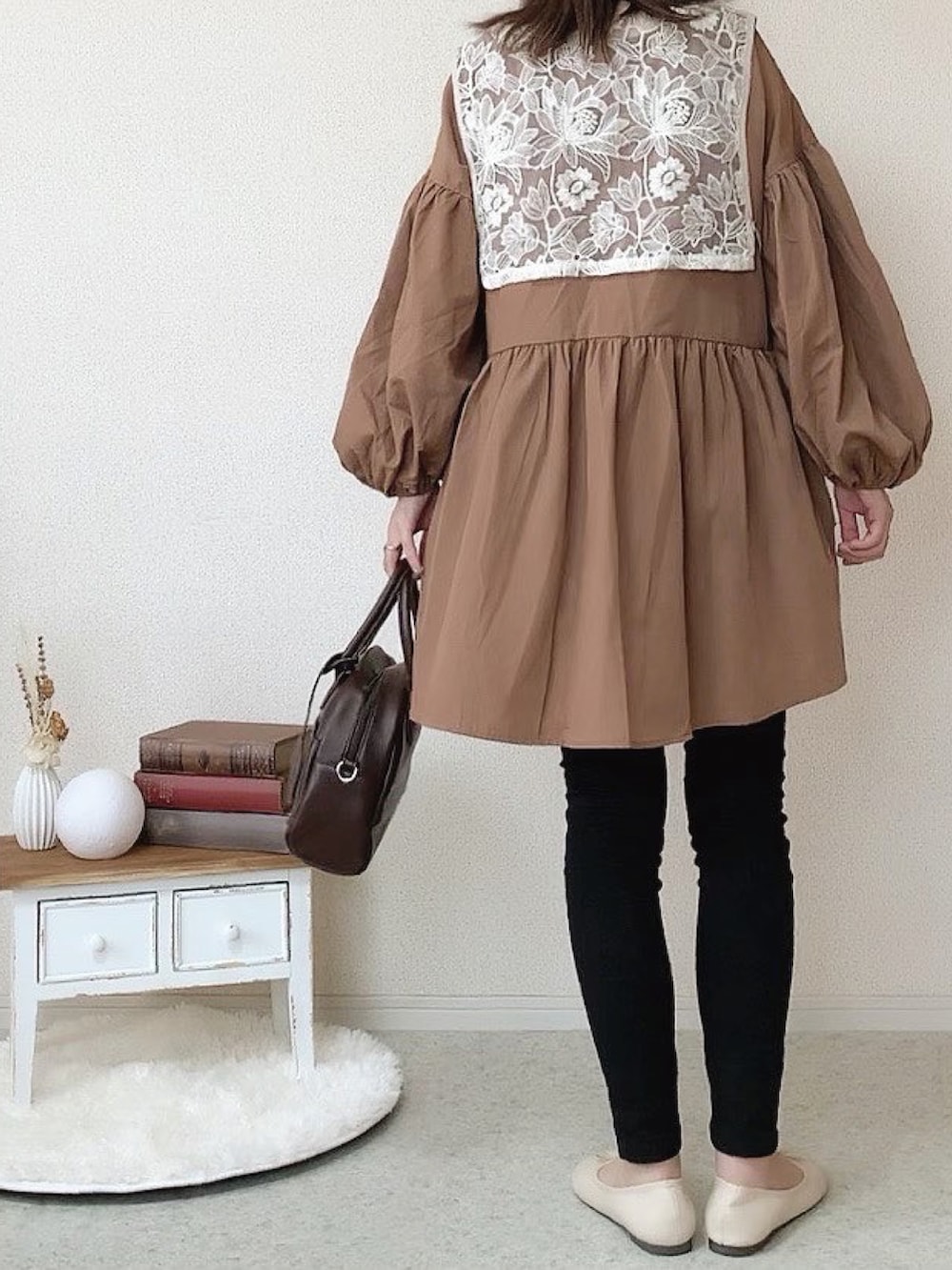 ホワイト系のベスト、ブラック系のデニムパンツ、ホワイト系のバレエシューズを着用したレディースの秋コーディネートの3枚目の写真