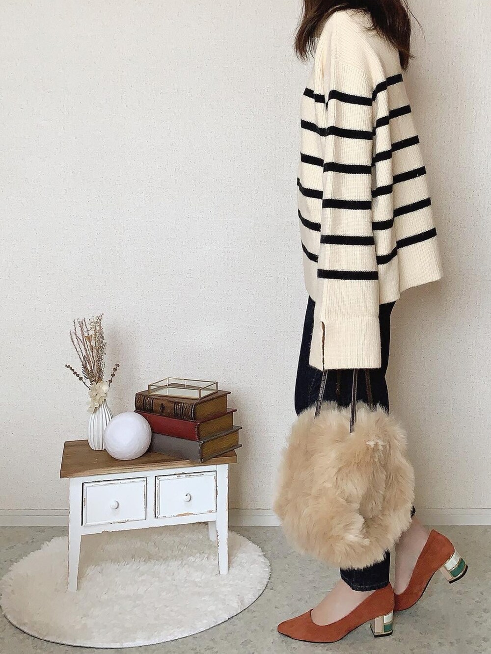 オレンジ系のパンプス、ブルー系のデニムパンツを着用したレディースの秋コーディネートの2枚目の写真