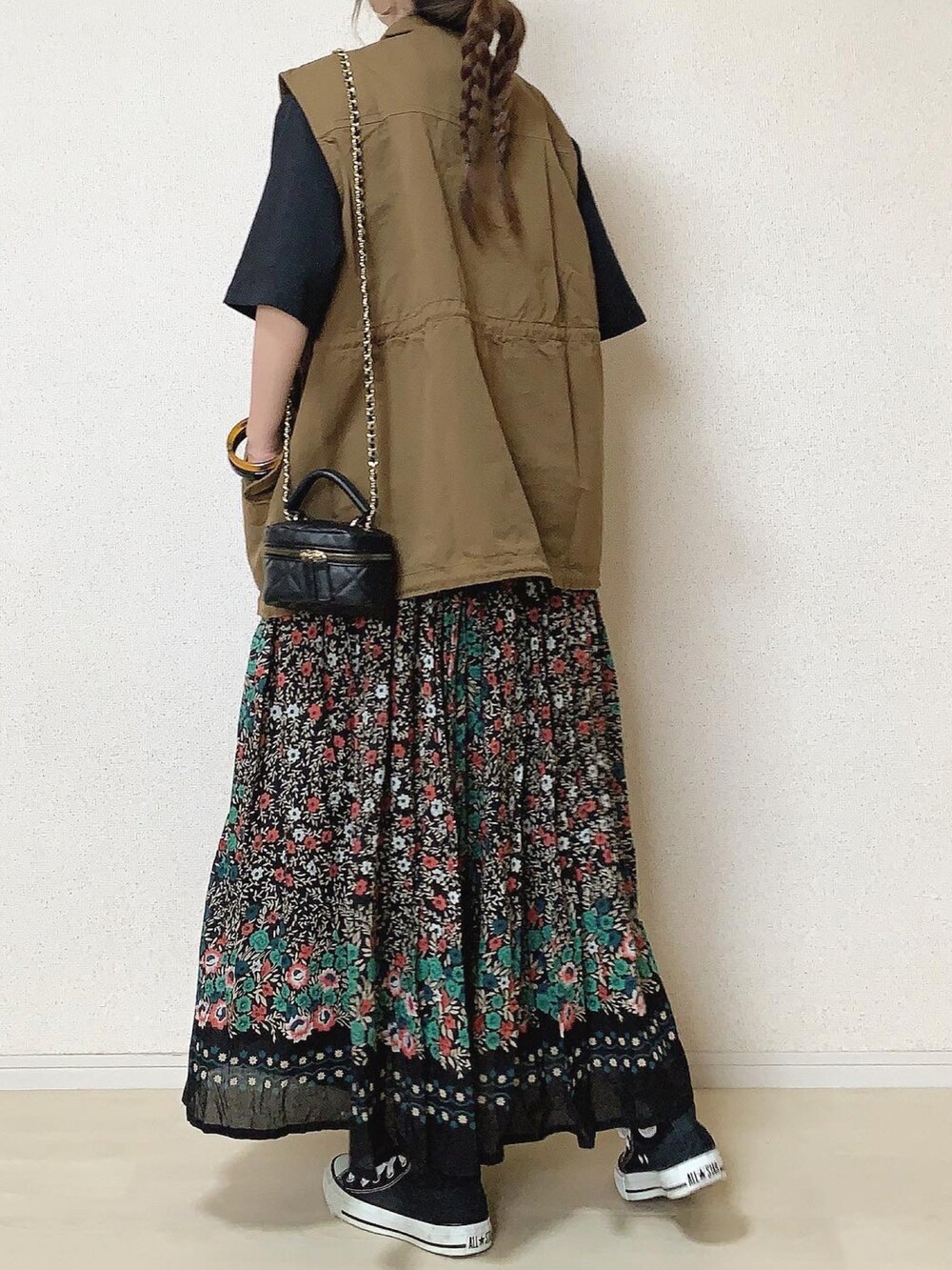 ブラック系のTシャツ/カットソー、ブラック系のスカート、ブラウン系のベストを着用したレディースの秋コーディネートの3枚目の写真