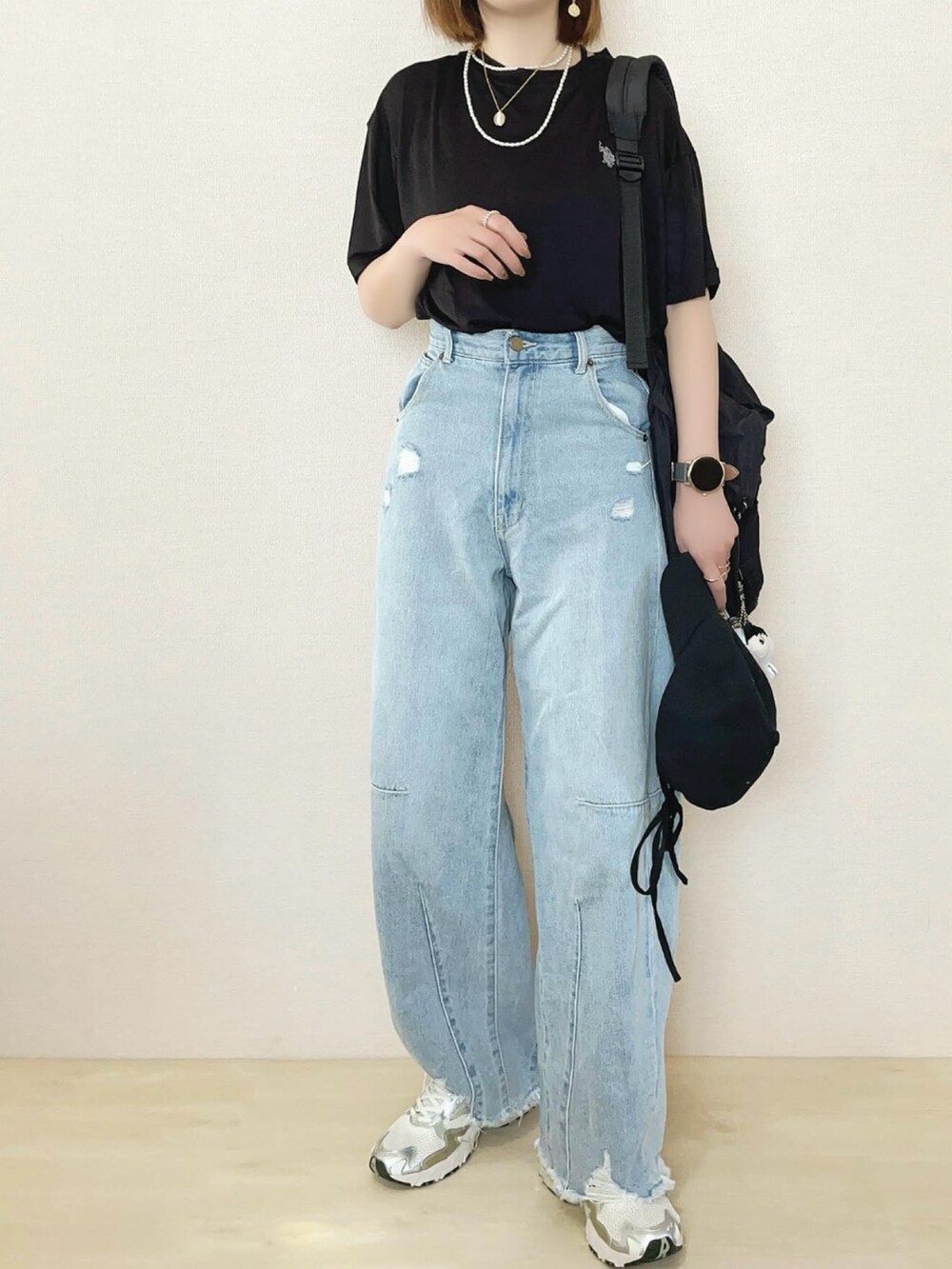 ブラック系のTシャツ/カットソー、ブルー系のデニムパンツを着用したレディースの春コーディネートの2枚目の写真