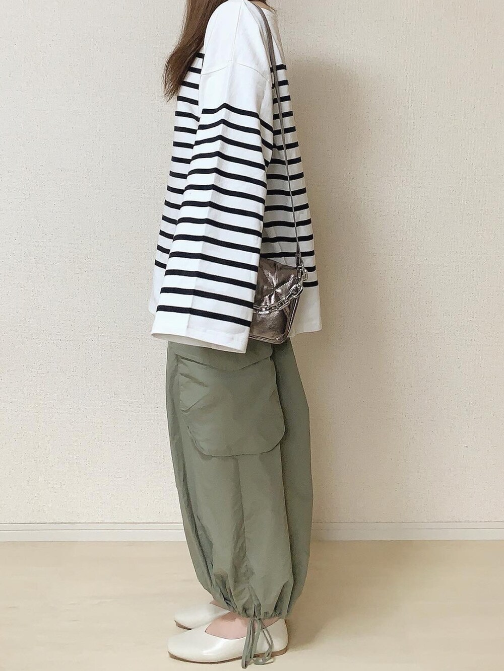 グリーン系のカーゴパンツ、ホワイト系のTシャツ/カットソーを着用したレディースの秋コーディネートの2枚目の写真