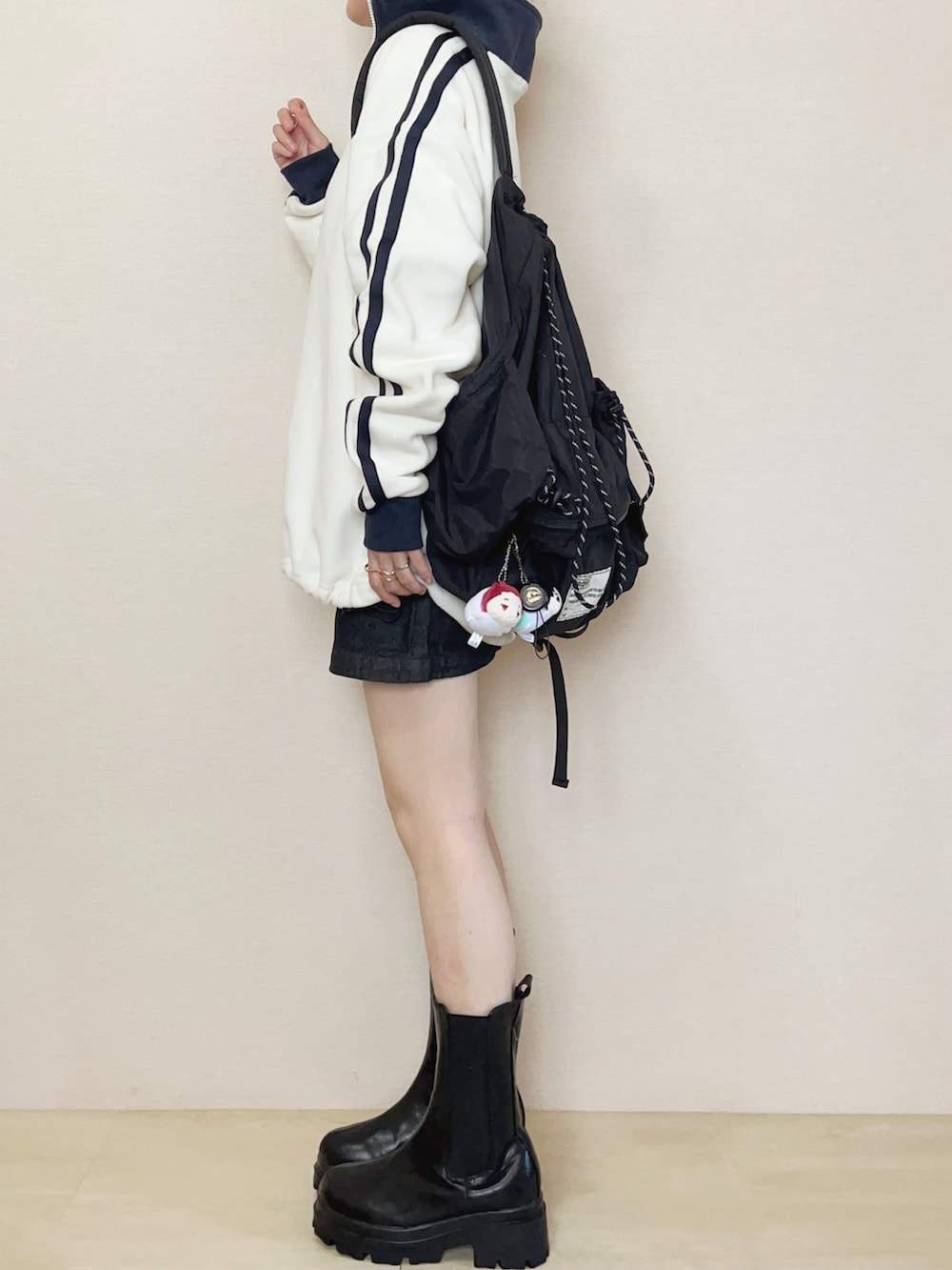 ホワイト系のスウェット、ブルー系のデニムスカート、ブラック系のブーツを着用したレディースの秋コーディネートの3枚目の写真