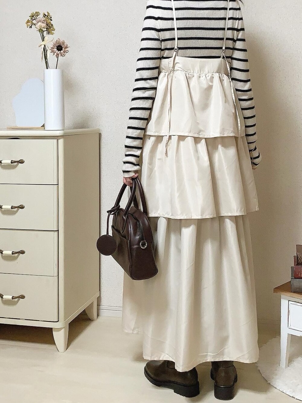 ゴールド系のネックレス、ゴールド系のピアス（両耳用）を着用したレディースの冬コーディネートの2枚目の写真