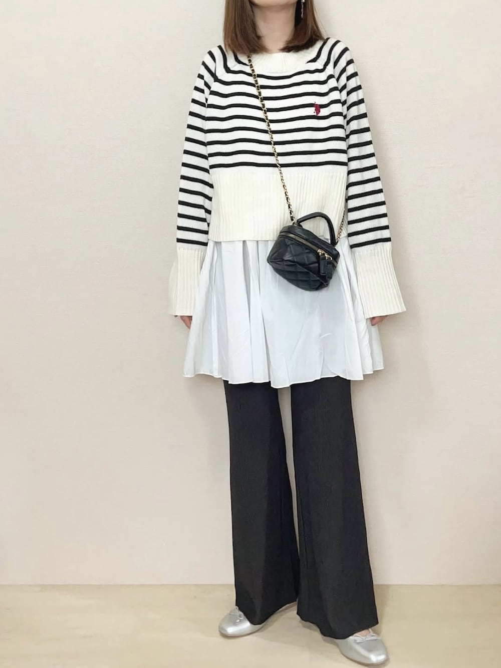 グレー系のその他パンツ、ホワイト系のニット/セーターを着用したレディースの冬コーディネートの2枚目の写真