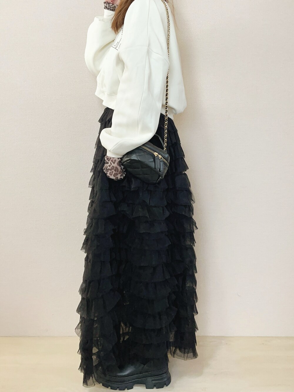 ベージュ系のスウェット、ブラック系のスカートを着用したレディースの冬コーディネートの2枚目の写真