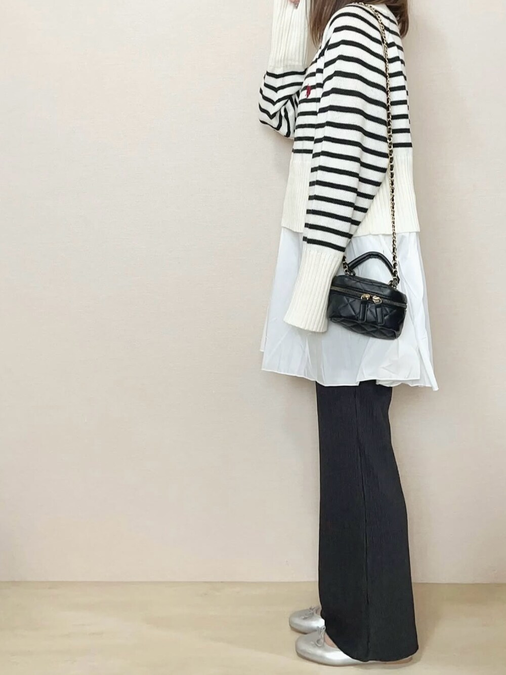 グレー系のその他パンツ、ホワイト系のニット/セーターを着用したレディースの冬コーディネートの3枚目の写真