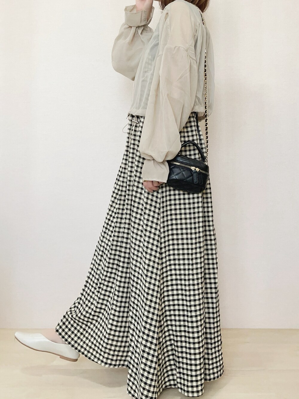 ベージュ系のブルゾン、ブラック系のワンピースを着用したレディースの春コーディネートの3枚目の写真