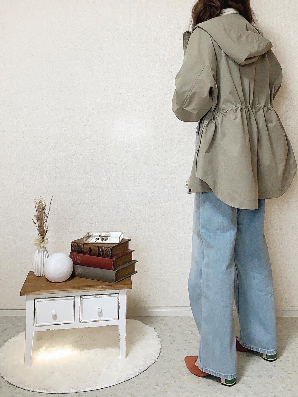 オレンジ系のパンプス、ゴールド系のピアス（両耳用）を着用したレディースの冬コーディネートの2枚目の写真