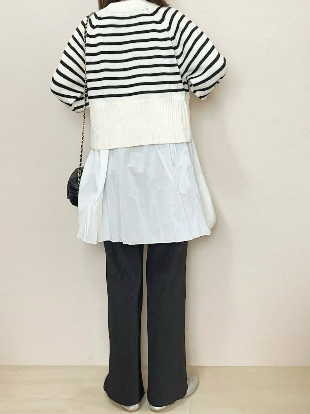 グレー系のその他パンツ、ホワイト系のニット/セーターを着用したレディースの冬コーディネートの4枚目の写真