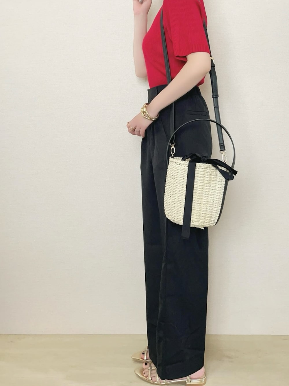 ブラック系のスラックス、レッド系のニット/セーターを着用したレディースの春コーディネートの3枚目の写真