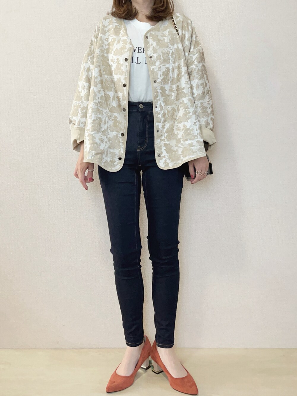 ホワイト系のシャツ/ブラウス、ホワイト系のTシャツ/カットソー、オレンジ系のパンプスを着用したレディースの秋コーディネートの2枚目の写真