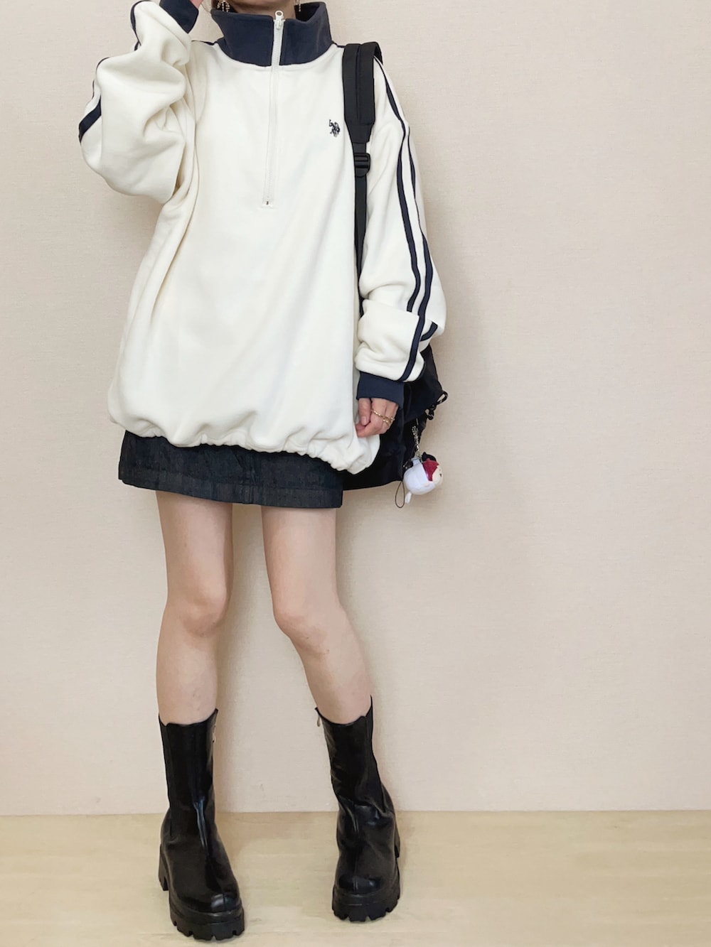 ホワイト系のスウェット、ブルー系のデニムスカート、ブラック系のブーツを着用したレディースの秋コーディネートの2枚目の写真