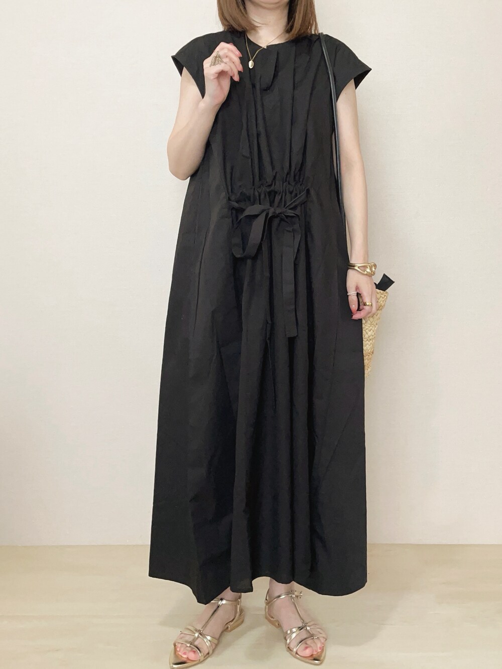 ブラック系のワンピースを着用したレディースの春コーディネートの2枚目の写真