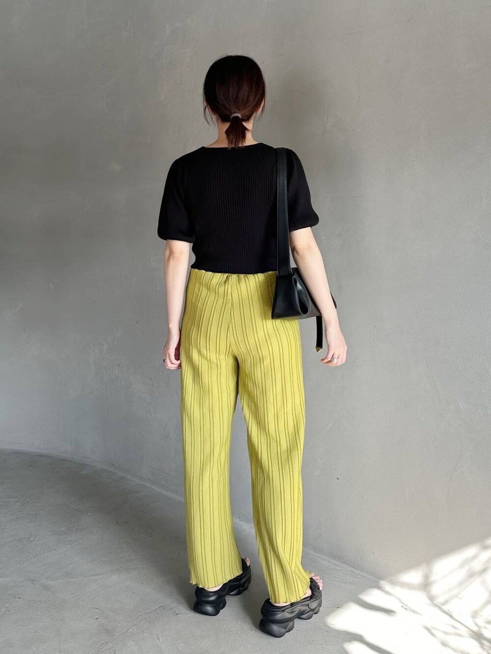 ブラック系のニット/セーター、ブラック系のサンダル、グリーン系のその他パンツを着用したレディースの春コーディネートの3枚目の写真