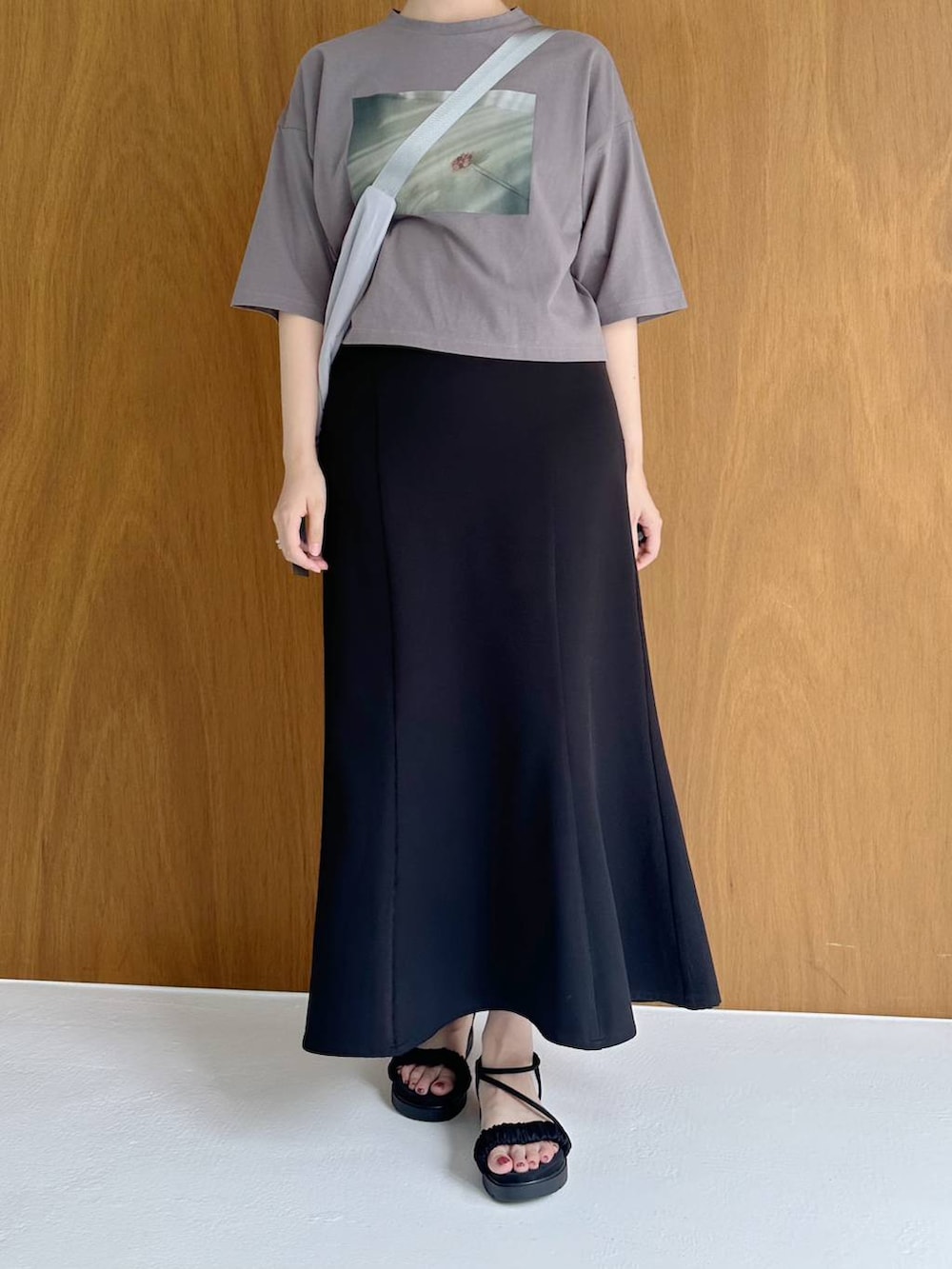 ブラック系のサンダル、グレー系のTシャツ/カットソー、ブラック系のスカートを着用したレディースの夏コーディネートの5枚目の写真