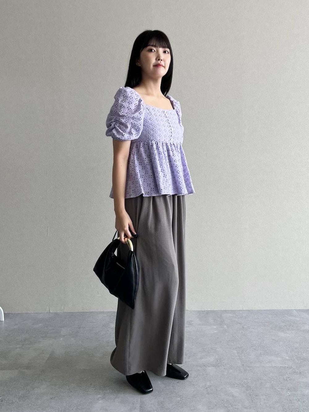 ブラック系のハンドバッグ、グレー系のその他パンツ、パープル系のシャツ/ブラウスを着用したレディースの夏コーディネートの2枚目の写真