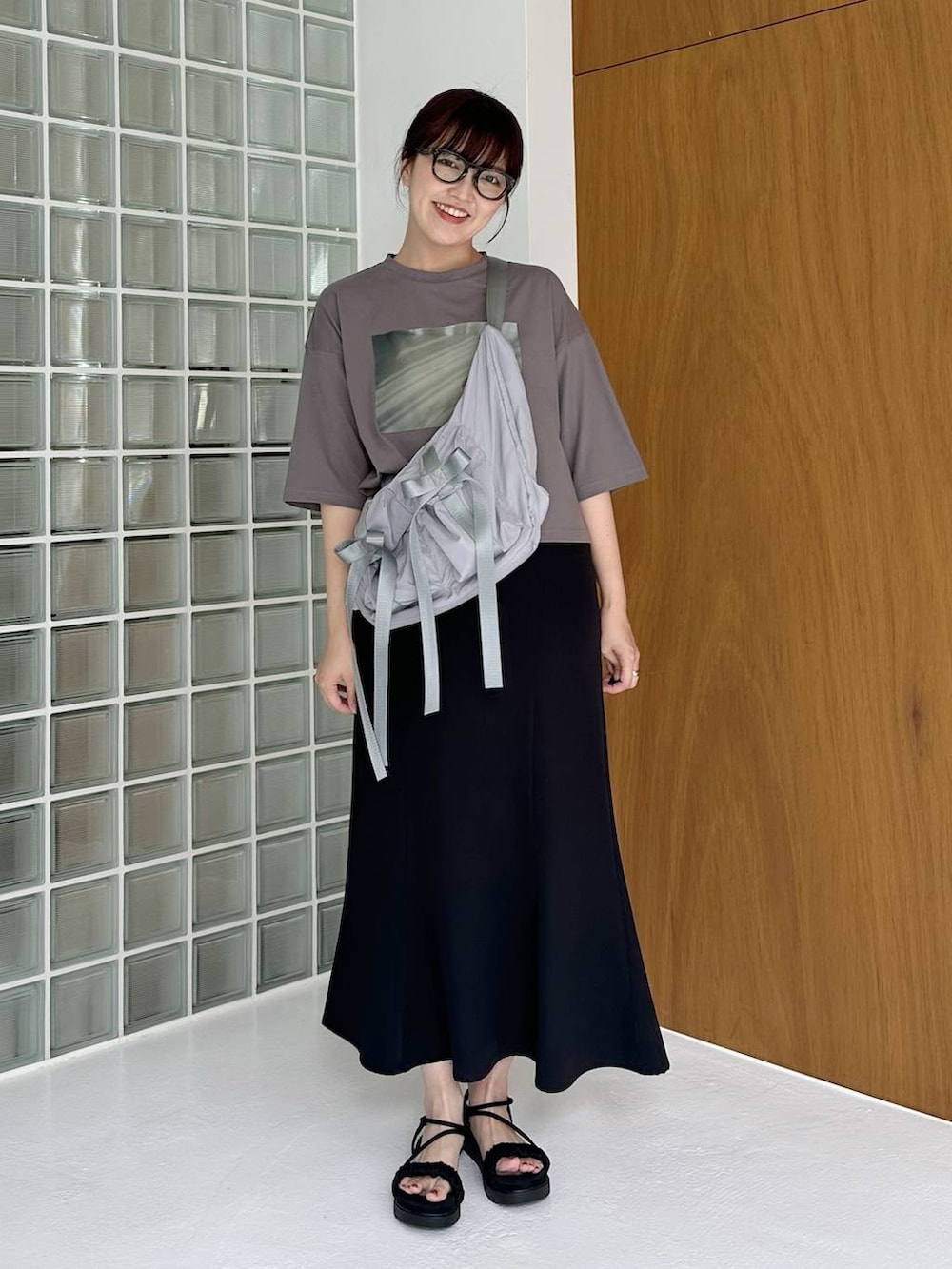 ブラック系のサンダル、グレー系のTシャツ/カットソー、ブラック系のスカートを着用したレディースの夏コーディネートの3枚目の写真