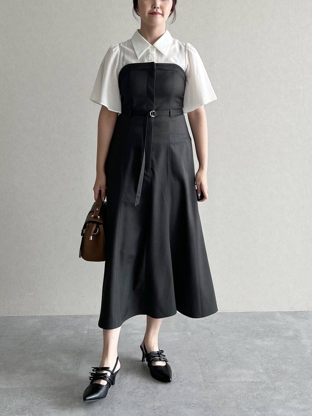 グレー系のワンピース、ブラック系のパンプス、ブラウン系のショルダーバッグを着用したレディースの夏コーディネートの3枚目の写真