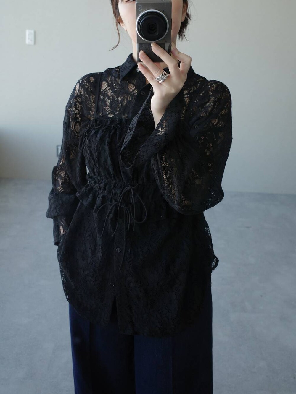 ブラック系のハンドバッグ、ブラック系のパンプス、ブルー系のデニムパンツを着用したレディースの冬コーディネートの3枚目の写真