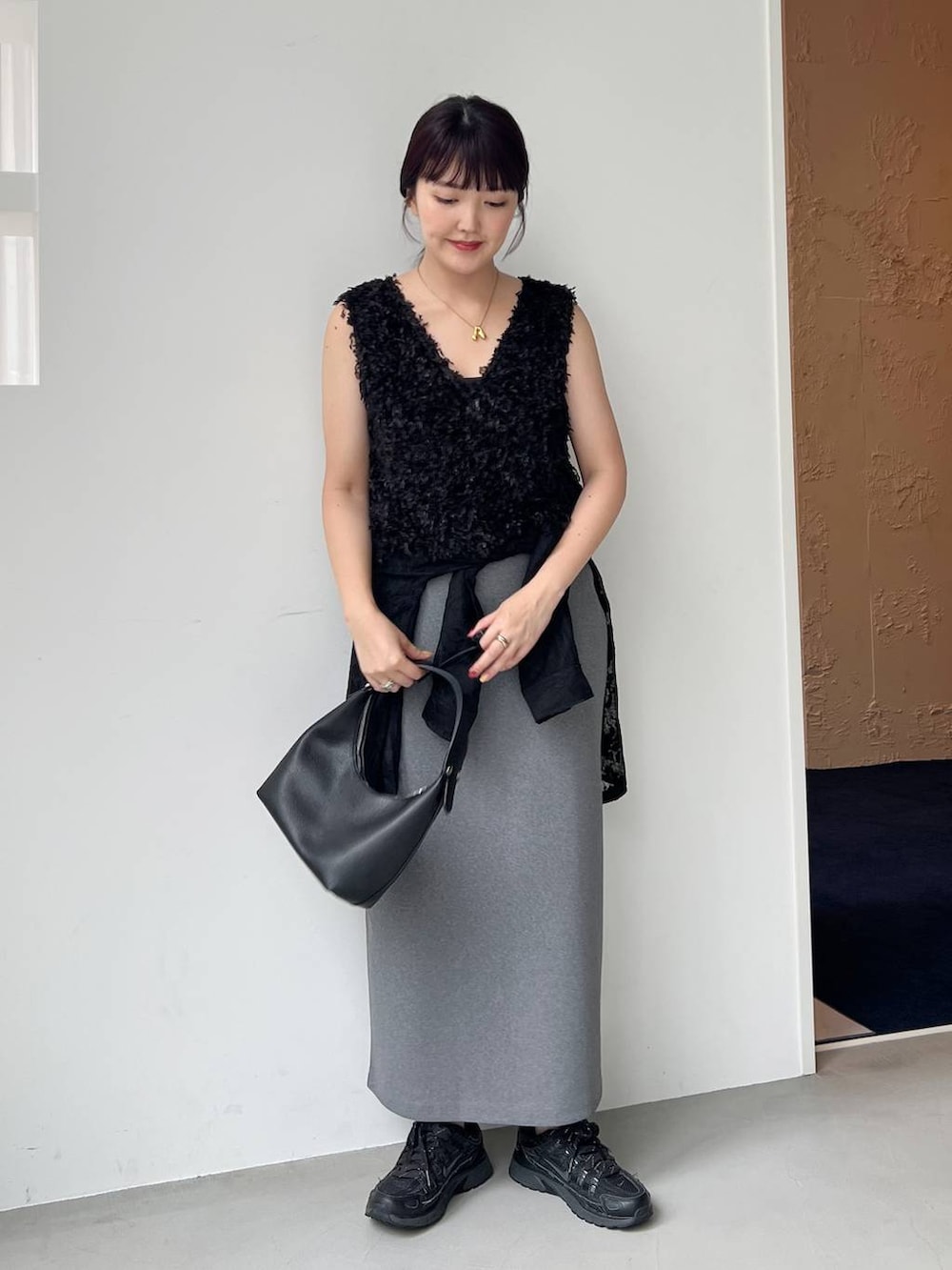 ブラック系のショルダーバッグ、ブラック系のシャツ/ブラウス、ブラック系のベストを着用したレディースの夏コーディネートの2枚目の写真