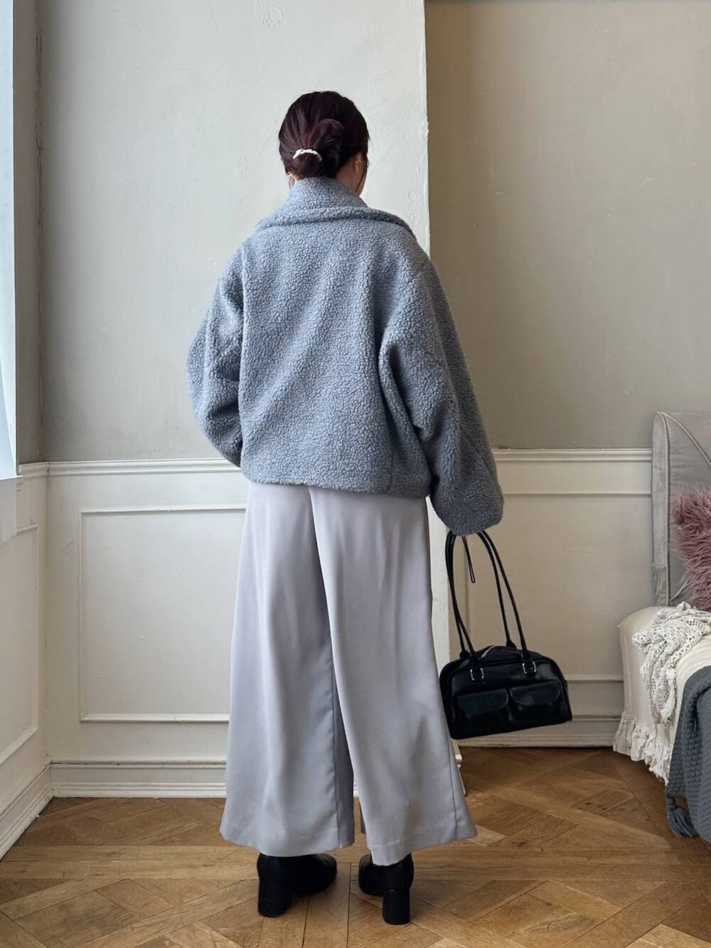 グレー系のピーコート、ブラック系のブーツ、ブルー系のTシャツ/カットソーを着用したレディースの秋コーディネートの3枚目の写真