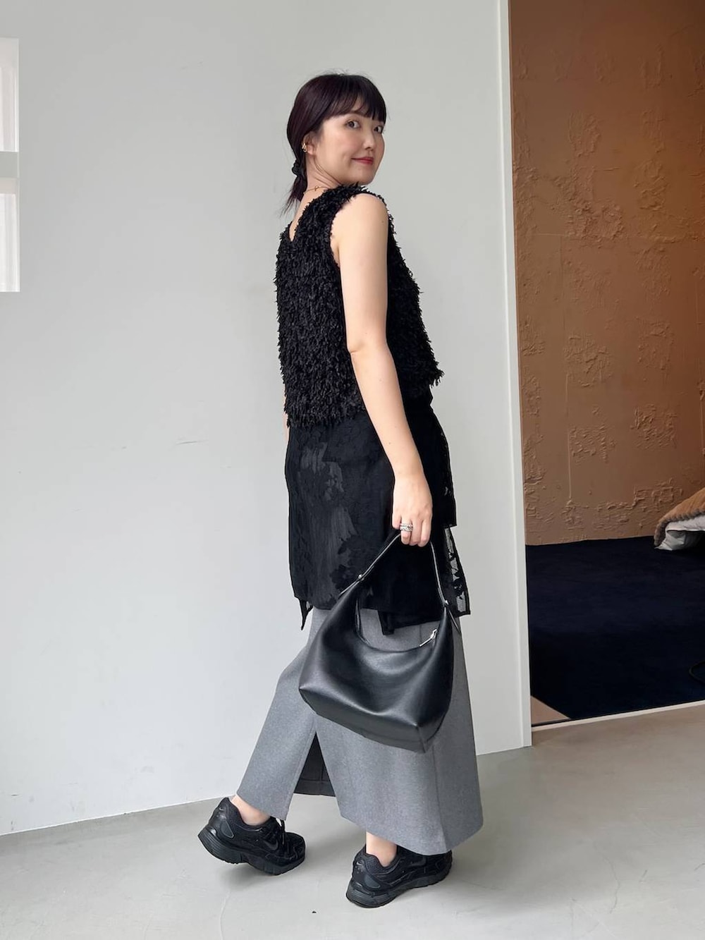 ブラック系のショルダーバッグ、ブラック系のシャツ/ブラウス、ブラック系のベストを着用したレディースの夏コーディネートの3枚目の写真