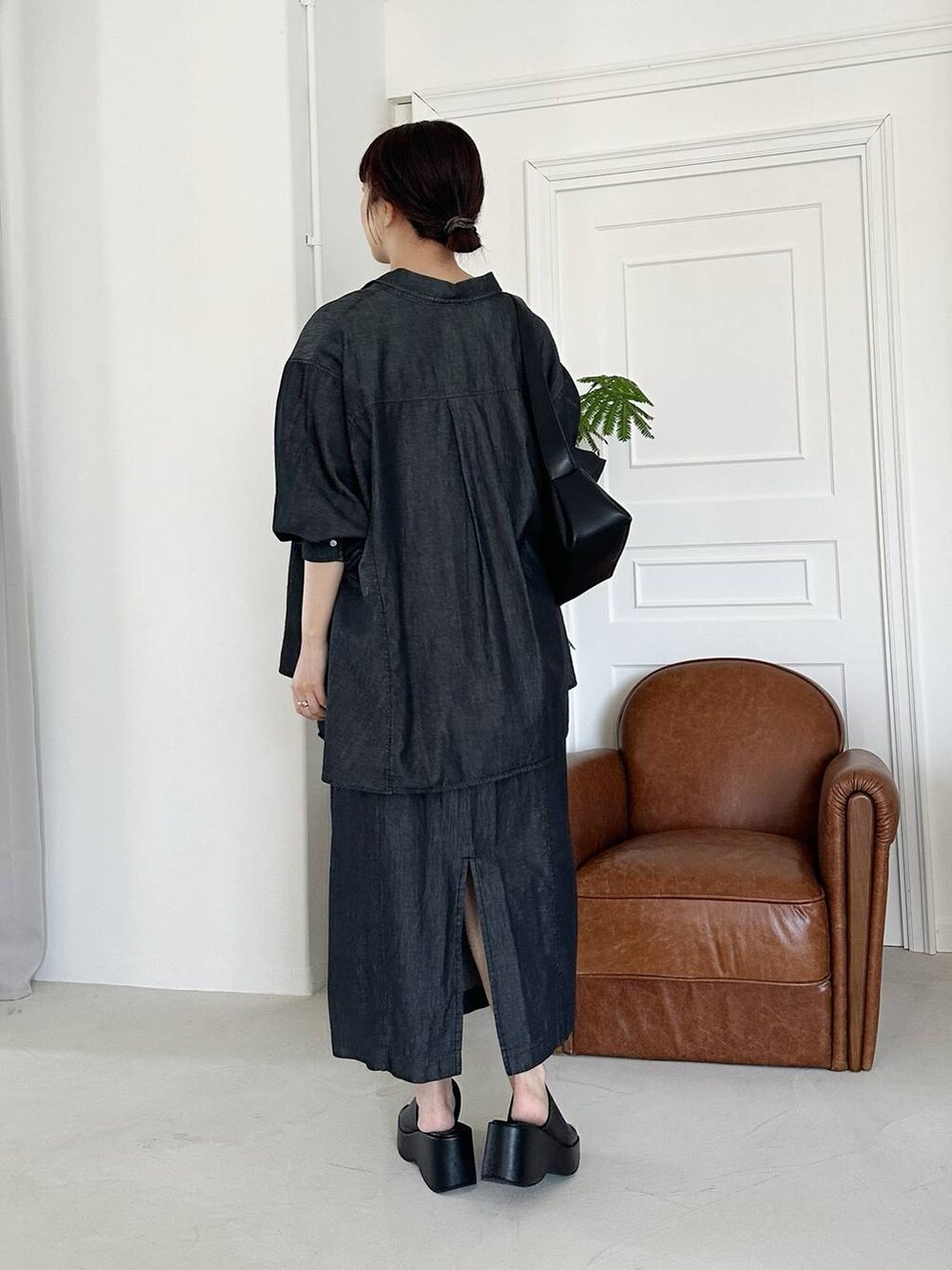 ブラック系のサンダル、ブラック系のショルダーバッグ、ブラック系のワンピースを着用したレディースの夏コーディネートの2枚目の写真