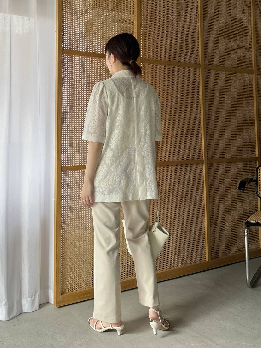 ベージュ系のその他パンツ、ホワイト系のハンドバッグ、ホワイト系のタンクトップを着用したレディースの春コーディネートの4枚目の写真