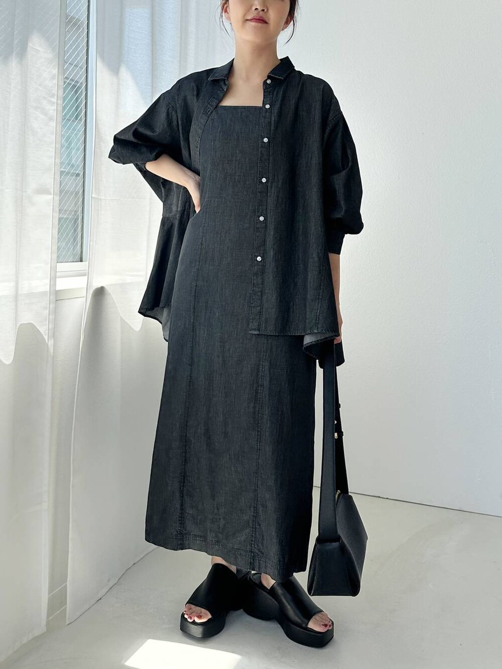 ブラック系のサンダル、ブラック系のショルダーバッグ、ブラック系のワンピースを着用したレディースの夏コーディネートの6枚目の写真